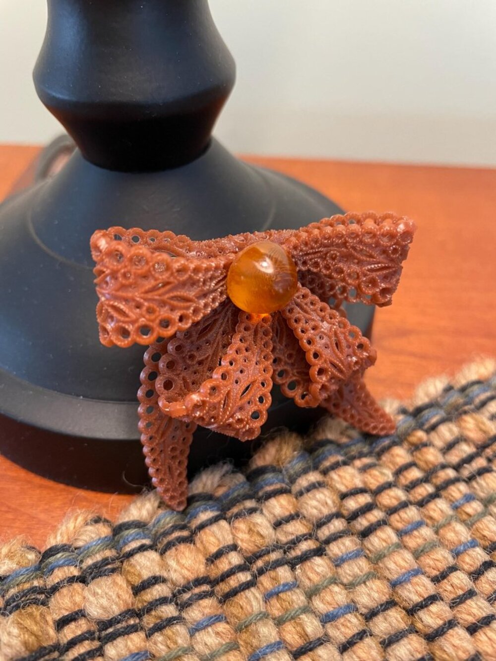 Vintage celluloid brooch pin featuring an amber colored bow design
